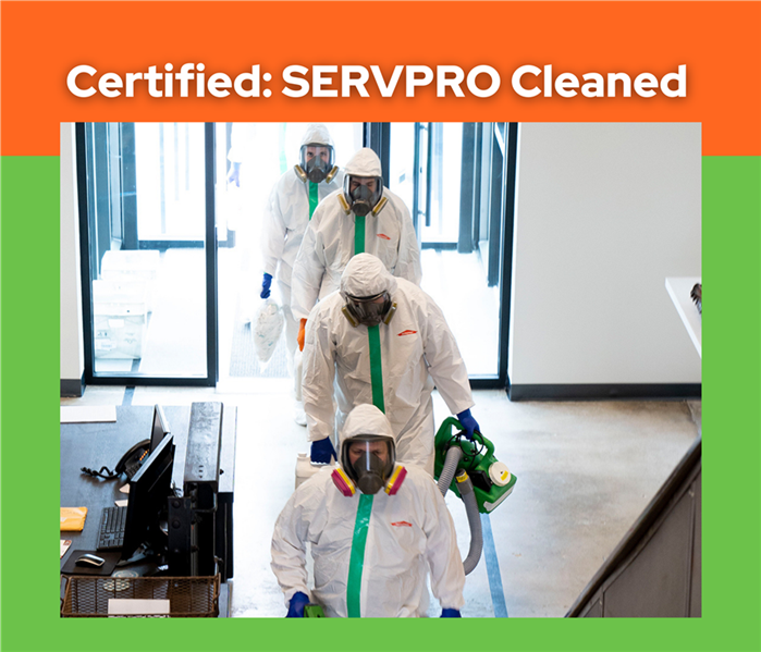 men in hazmat suits walking into a commercial building, photo taken from above, SERVPRO logo